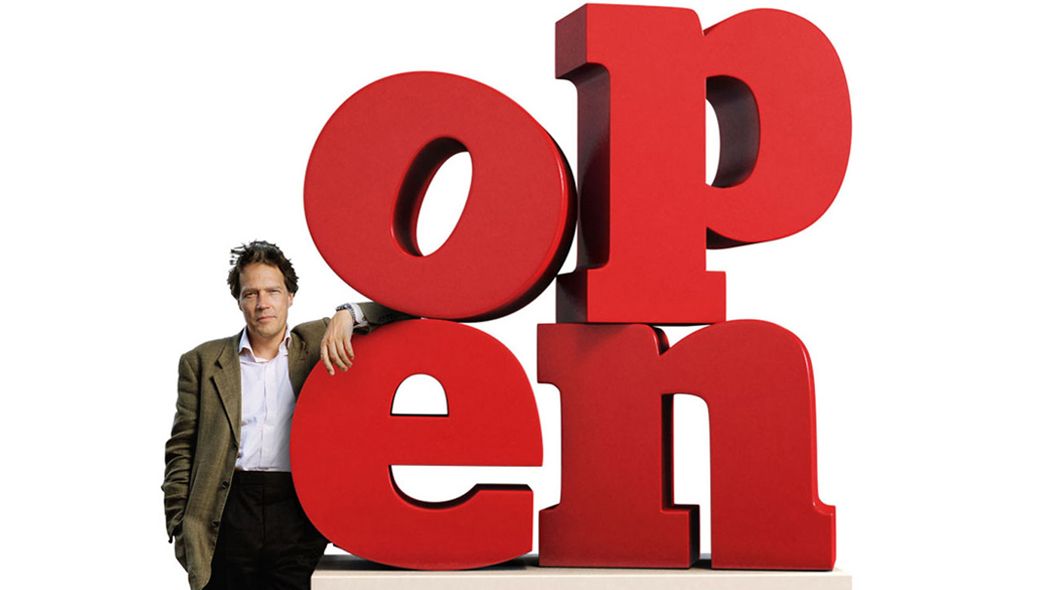 A smartly dressed man leans against large 3D text reading 'open'