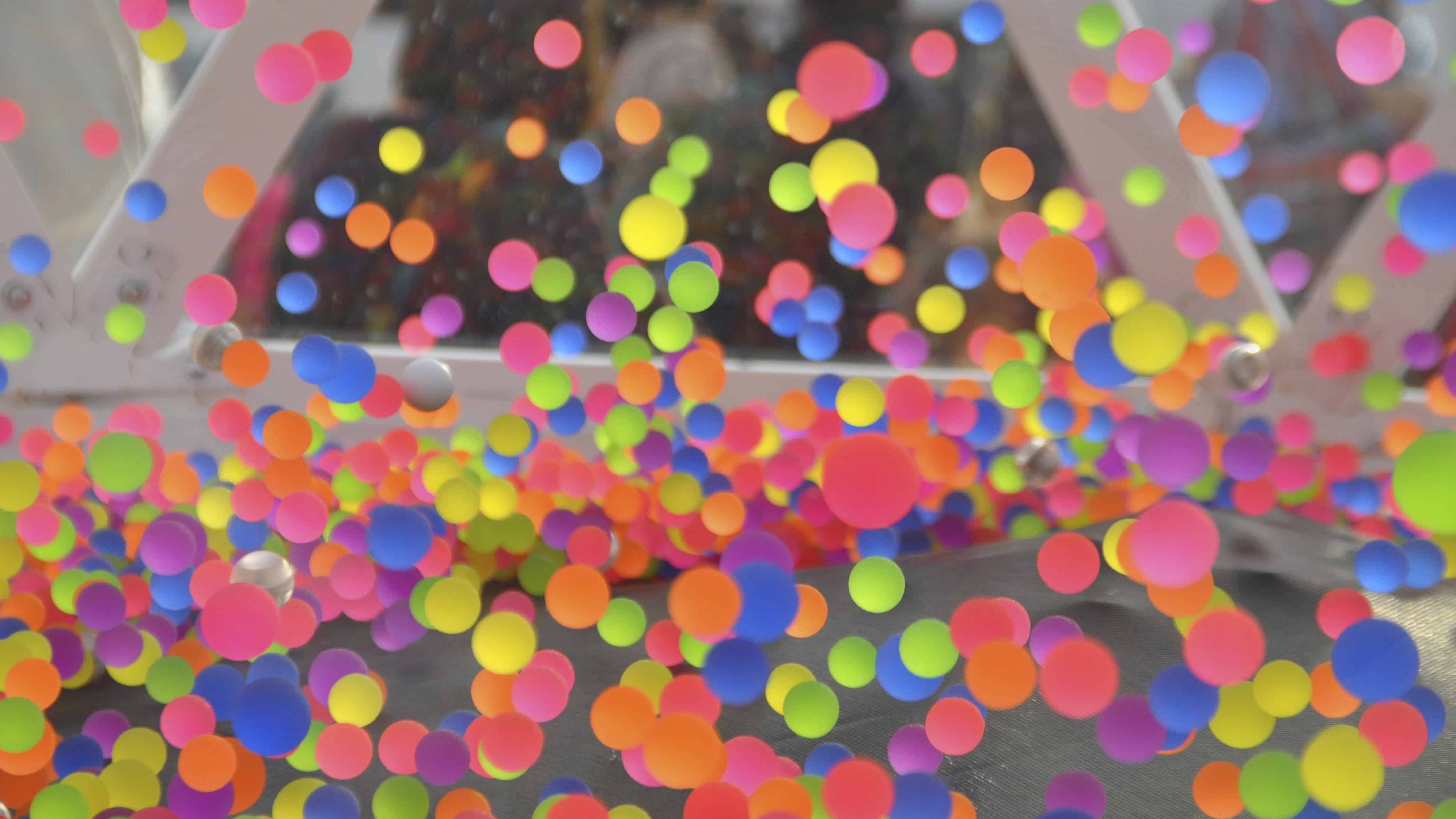Hundreds of multicoloured CGI bouncy balls bouncing on the floor